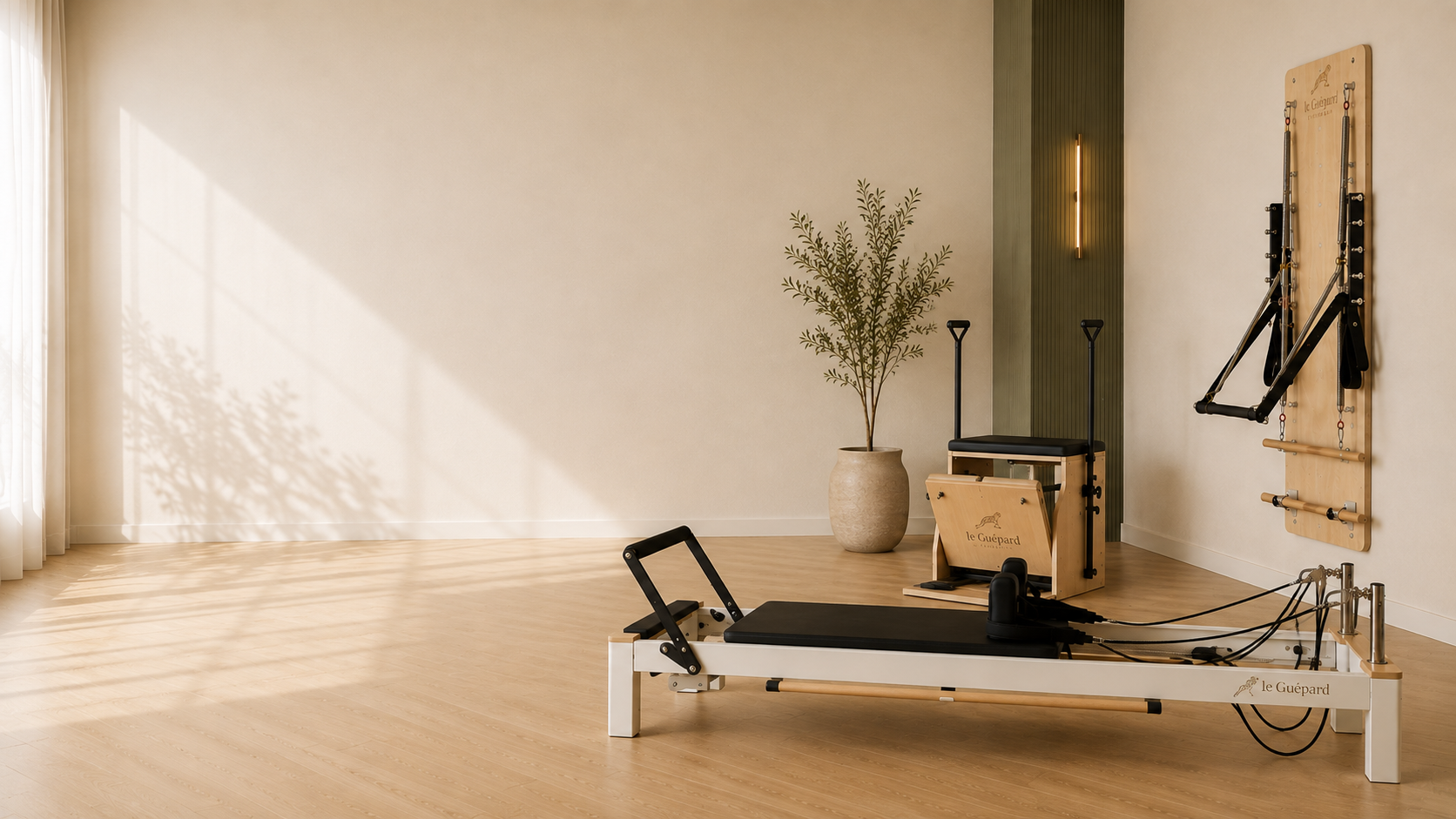 Studio de Pilates : Reformer et Chair devant un mur vert olive