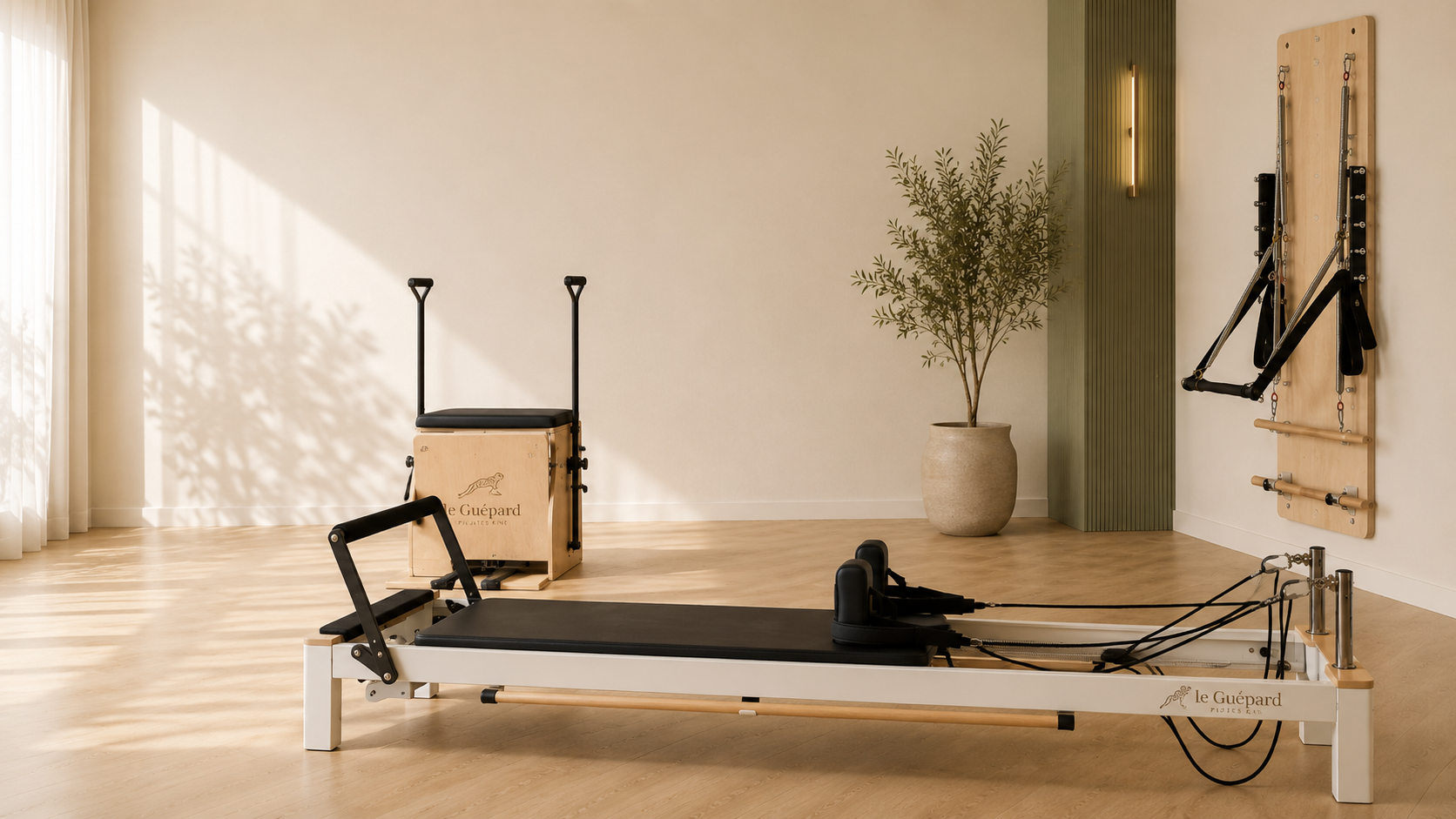 Vue large du studio : Reformer blanc au premier plan, Chair et mur vert au fond